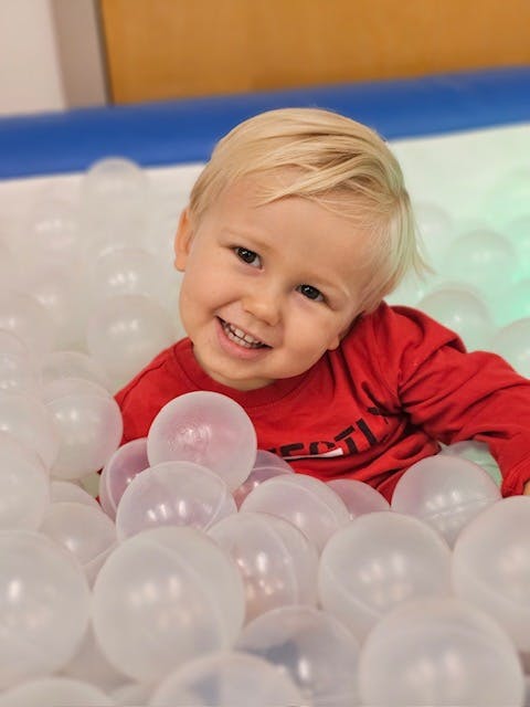 Little boy in plastic ball pool
